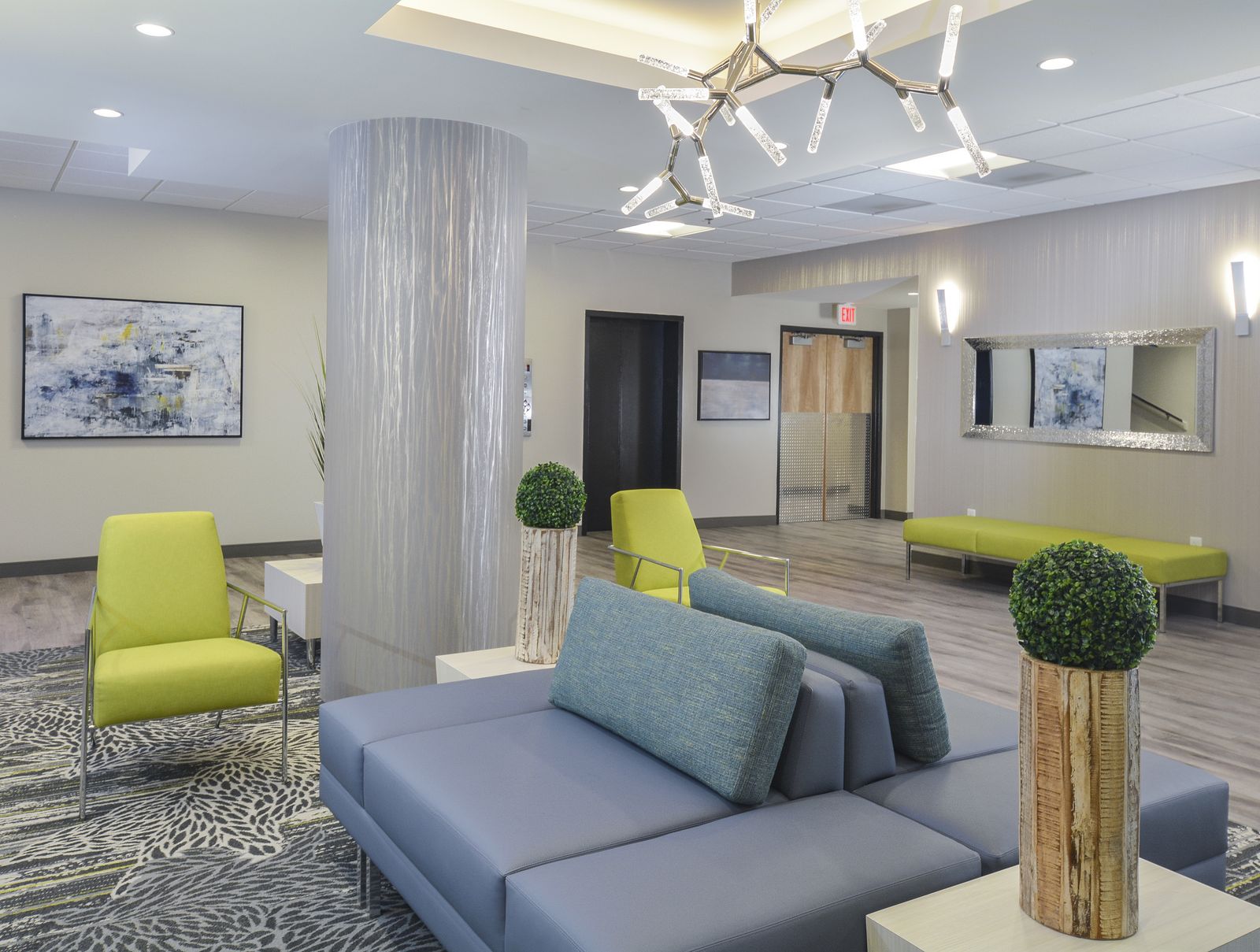 Lobby lounge with blue sofa and green accent chairs